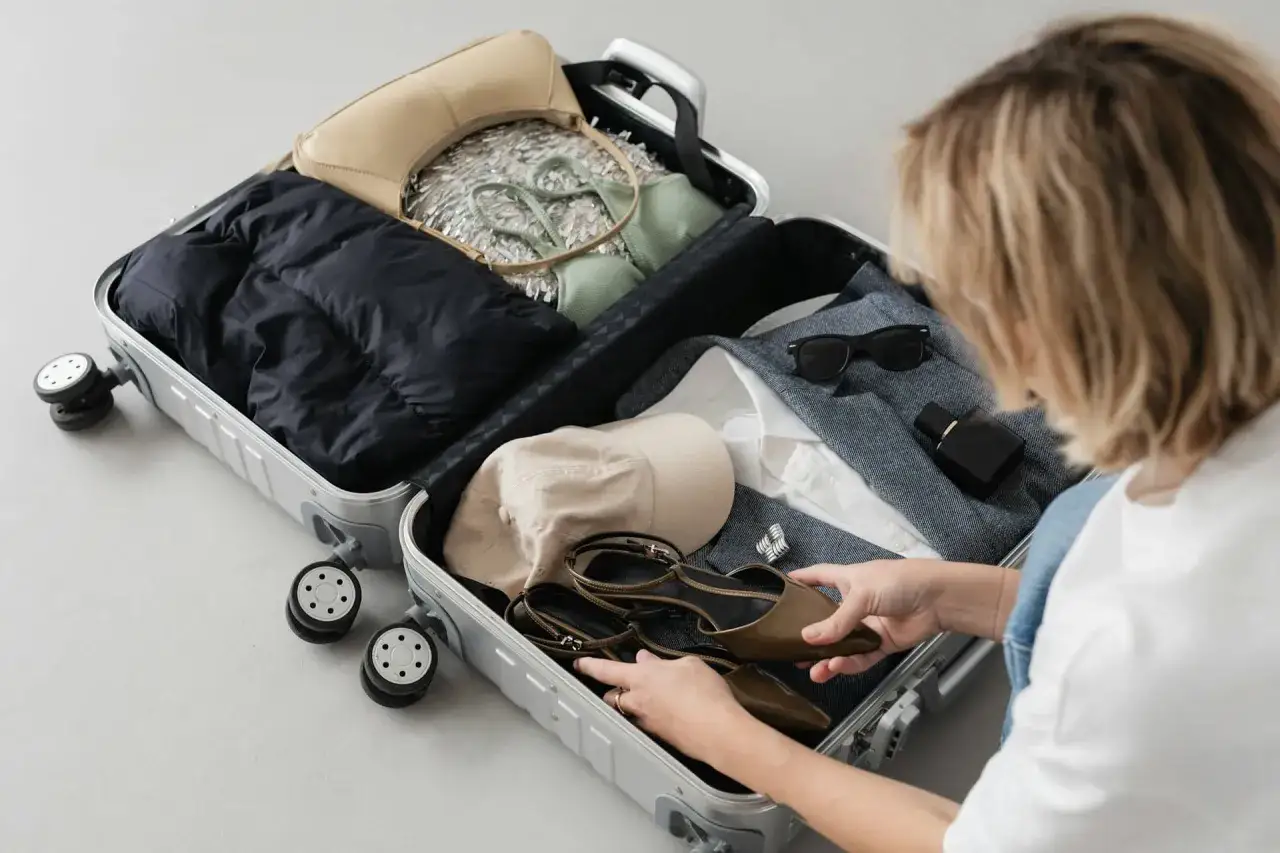 Pakowanie walizki: kurtka, torebka, bielizna, buty, czapka, okulary i perfumy. Czy można przewozić perfumy w bagażu rejestrowanym? Tak, zazwyczaj można.
