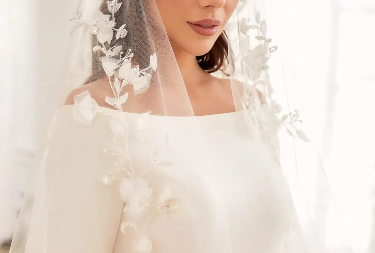 Panna młoda w koronkowej sukni ślubnej z delikatnymi dodatkami