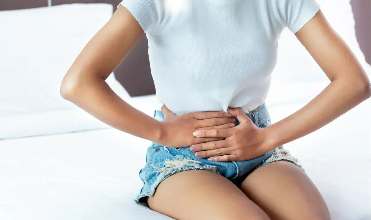 kobieta z bólem podbrzusza, kobieta trzymająca się za brzuch