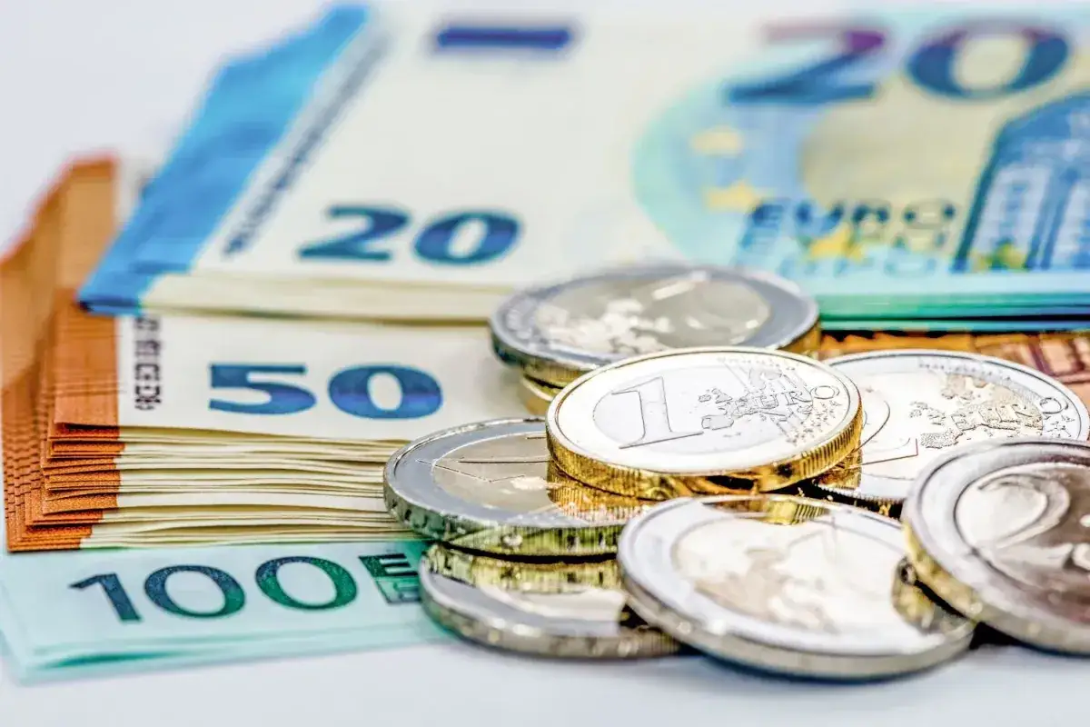 Stos banknotów euro (100, 50, 20) i monet. Zastanawiasz się, ile gotówki można mieć przy sobie w samolocie?