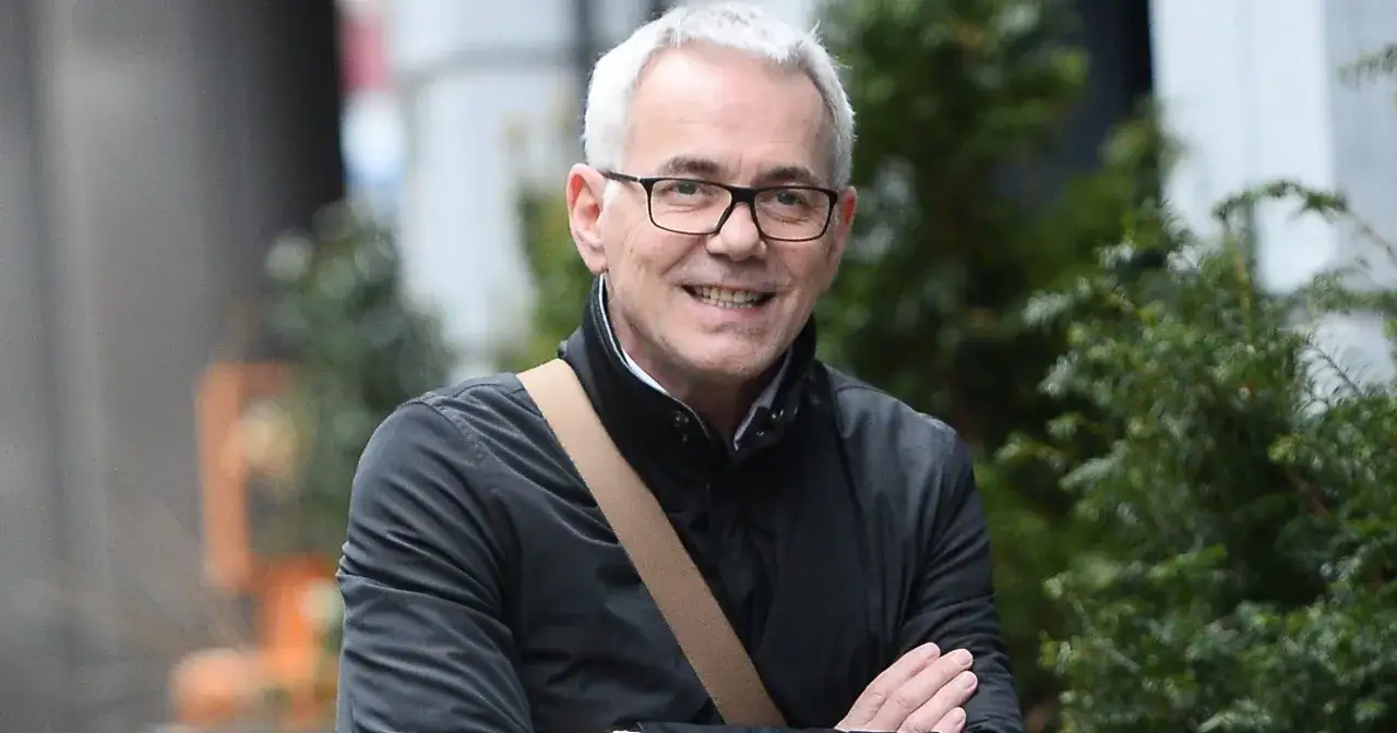 Uśmiechnięty mężczyzna w okularach, w czarnej kurtce, z torbą na ramieniu. Czy to on jest powodem, dlaczego fani bojkotują nową odsłonę programu Jaka to melodia?