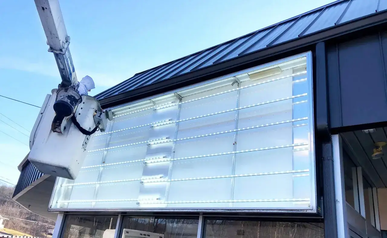 Montaż nowoczesnego oświetlenia **led zamiast świetl&oacute;wek** na dużym banerze reklamowym.