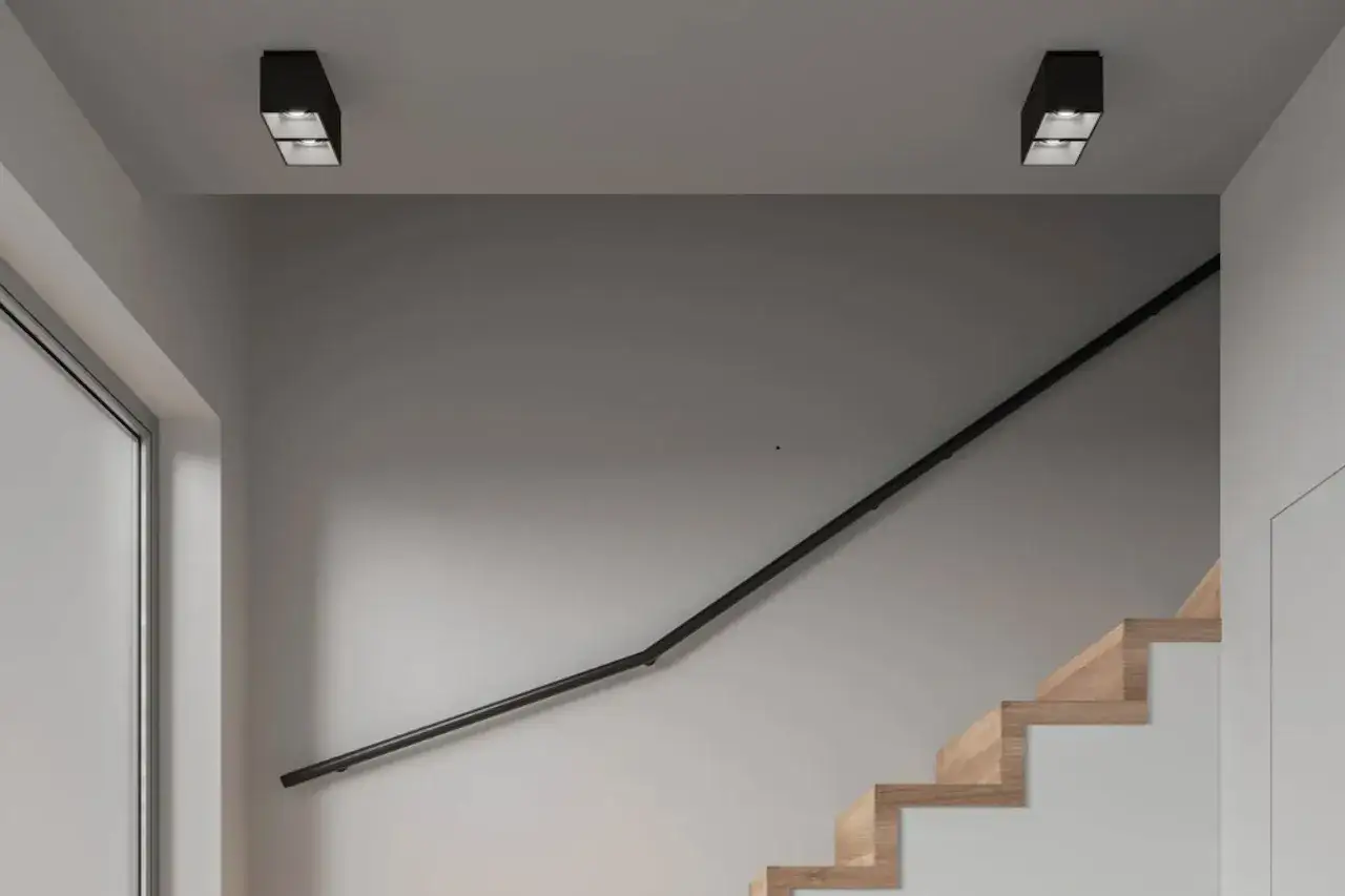 Nowoczesne oświetlenie schodów w poręczy, dyskretnie podkreślające drewniane stopnie i tworzące przytulną atmosferę.