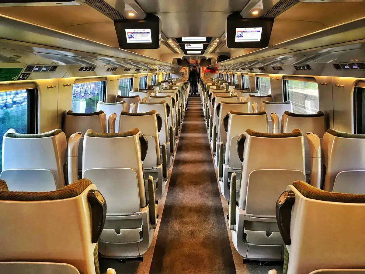 Wnętrze pociągu Pendolino, gotowego do podróży z Krakowa do Gdańska. Puste, wygodne fotele czekają na pasażerów.