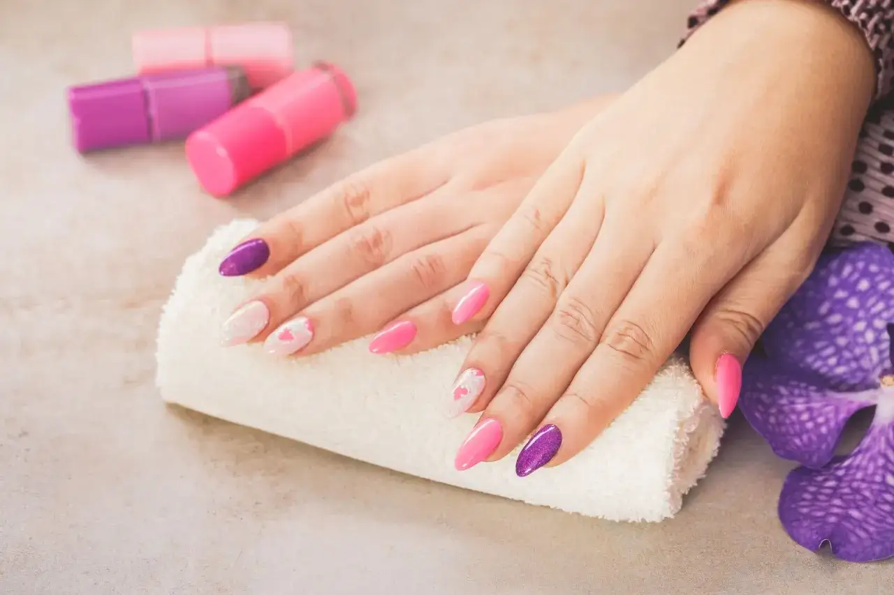 Delikatne paznokcie hybrydowe w ciąży, w odcieniach r&oacute;żu i fioletu, z subtelnymi zdobieniami.