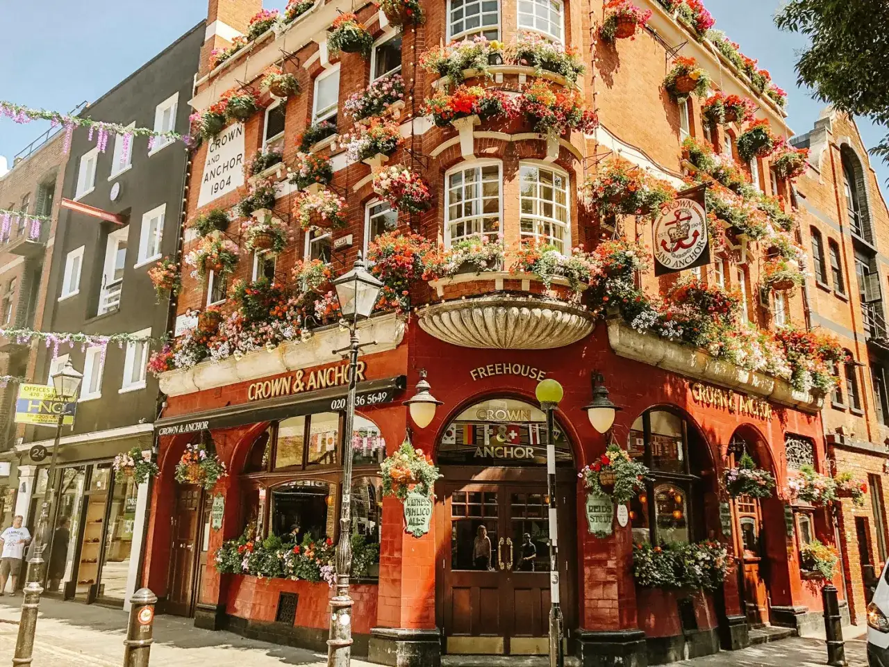 Uroczy pub Crown & Anchor w Londynie, ozdobiony mnóstwem kwiatów. Idealne miejsce, by poczuć atmosferę miasta i zastanowić się, gdzie najlepiej nocować w Londynie.
