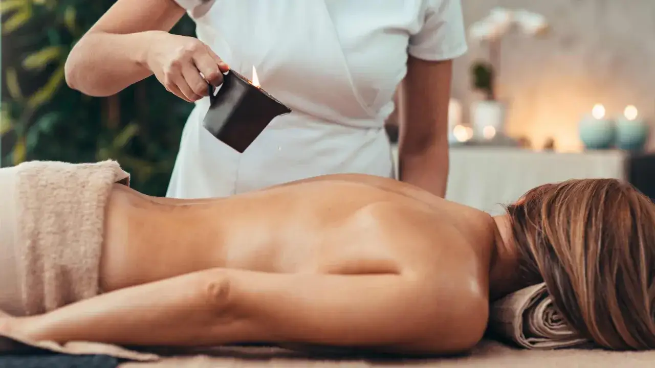 Relaksacyjny masaż pleców z użyciem gorącego oleju. Terapeuta polewa plecy klienta ciepłym olejkiem, co jest kluczowe, by wiedzieć jak masować plecy.