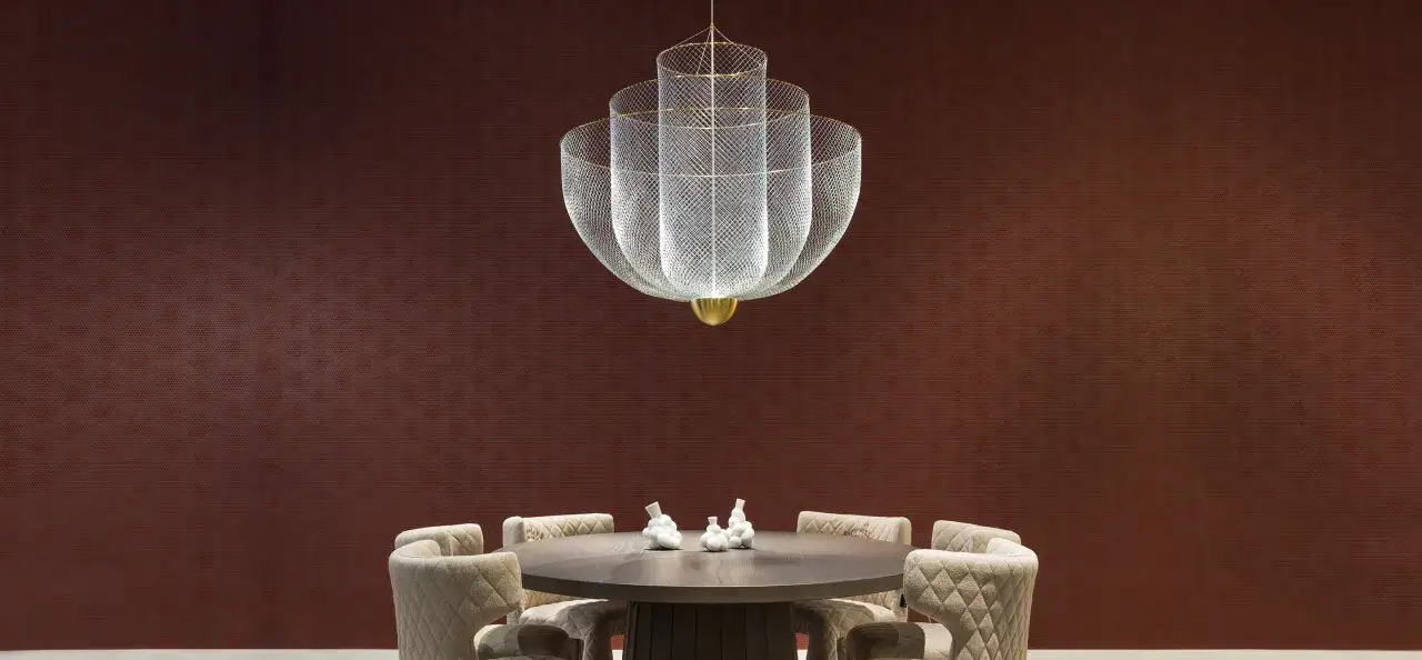 Elegancki żyrandol polskiego producenta żyrandoli wisi nad okrągłym stołem z tapicerowanymi krzesłami.