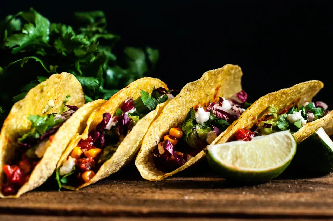 Cztery chrupiące taco z fasolą, kukurydzą, czerwoną kapustą i guacamole. Idealne, by pokazać, jak zrobić taco wegetariańskie.