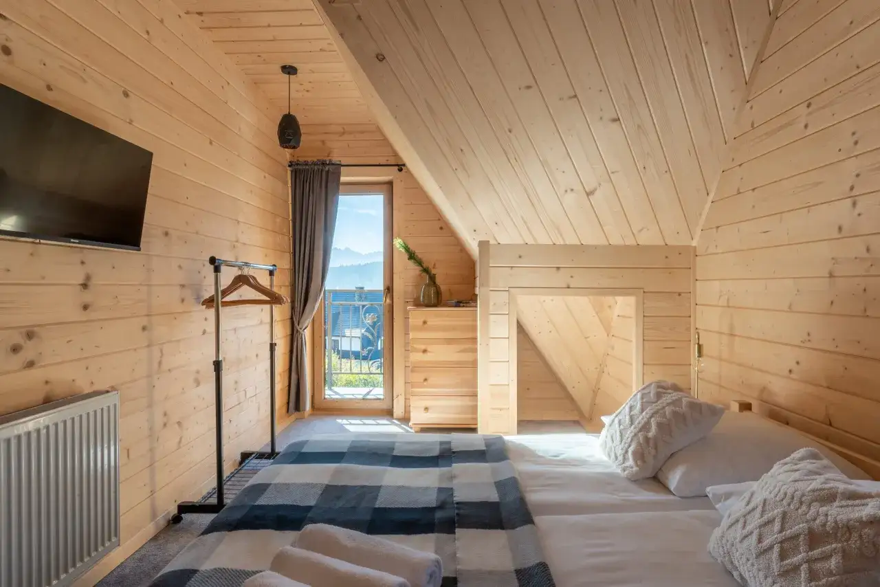 Przytulny domek w Bukowinie Tatrzańskiej. Drewniane wnętrze, wygodne ł&oacute;żko z pledem, widok na g&oacute;ry z okna.