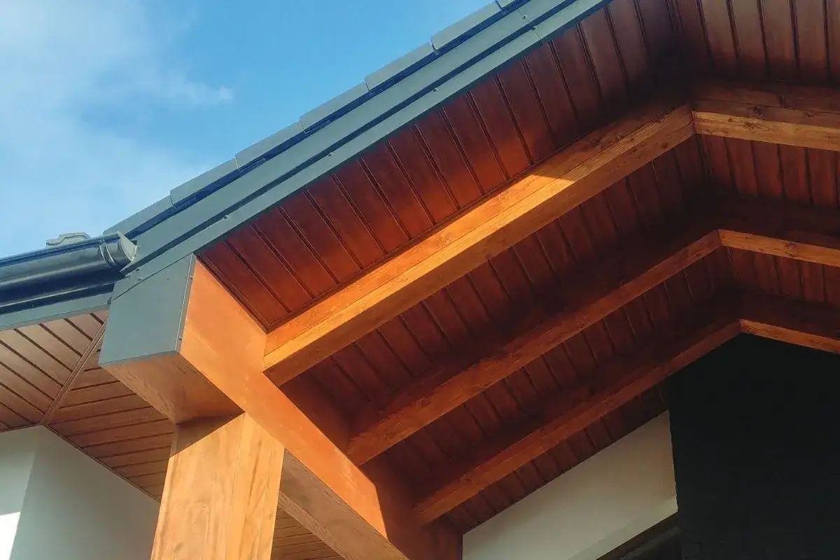 Drewniana podbitka idealnie komponuje się z grafitowym dachem, tworząc ciepły i elegancki wygląd domu.