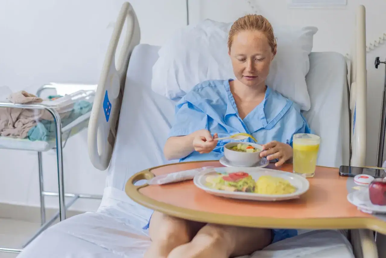 Kobieta po cesarce je posiłek w szpitalu. Posiłek jest lekki, co jest ważne, bo po cesarce czego nie wolno jeść, by szybko wr&oacute;cić do zdrowia.
