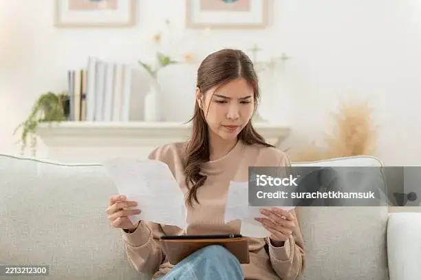 osoba analizująca dokumenty finansowe w domu