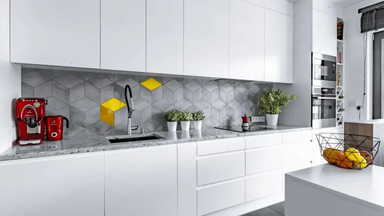 Nowoczesna kuchnia z szarymi płytkami w geometryczne wzory. Jaki kolor fugi do szarych płytek? Tu wygląda na ciemnoszarą, idealnie komponującą się z blatem.