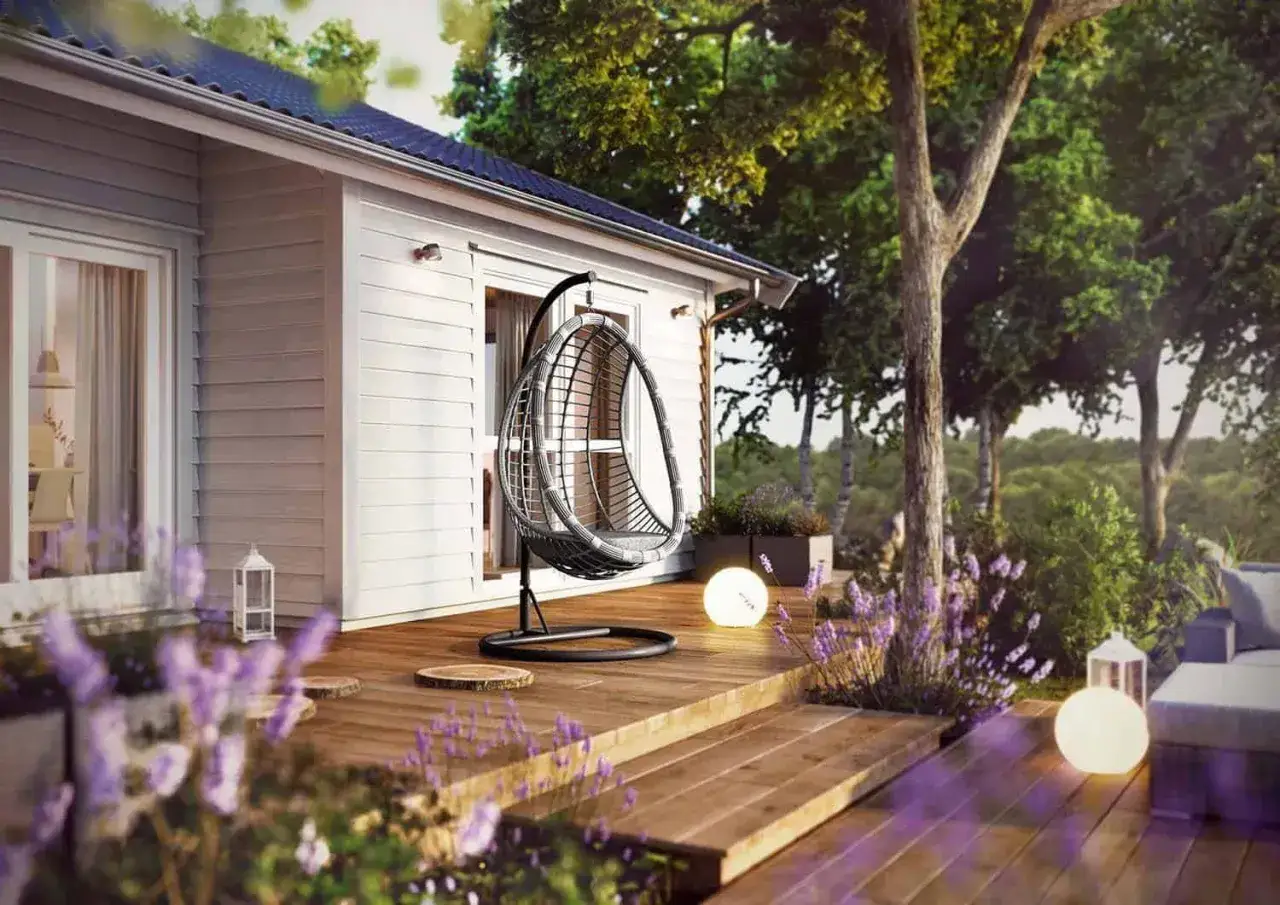 Mały taras przy domu z huśtawką, lampami i lawendą. Idealne miejsce na relaks.