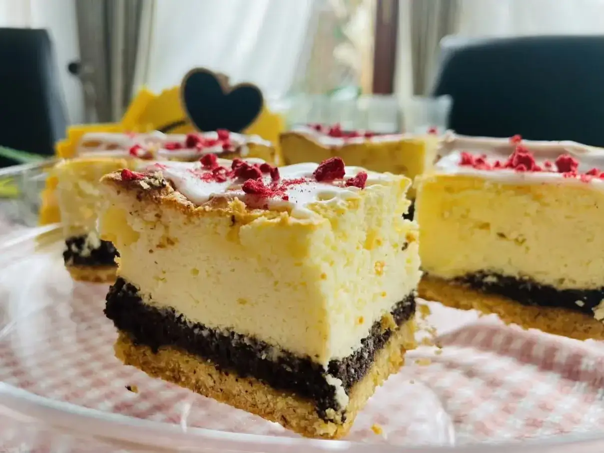 Pyszny sernik z makiem, udekorowany lukrem i malinami, kusi swoim wyglądem. Idealny na każdą okazję.