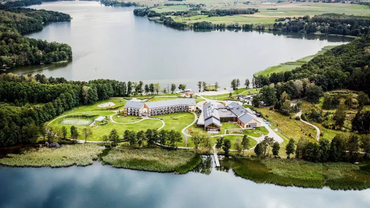 Malowniczy spa na Mazurach, z hotelem nad jeziorem, otoczony zielenią i lasem. Idealne miejsce na relaks.