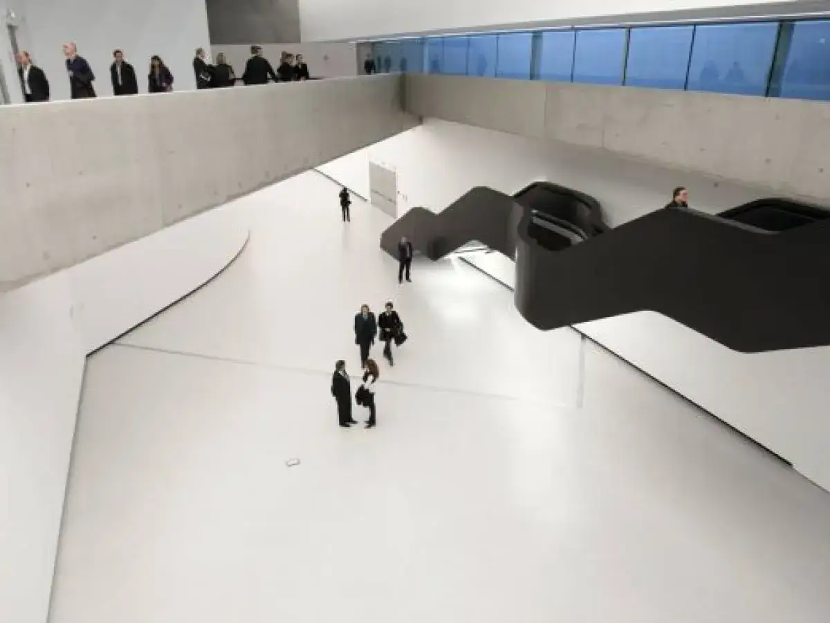 Wnętrze rzymskiego muzeum sztuki nowoczesnej z nowoczesnymi schodami i ludźmi zwiedzającymi.