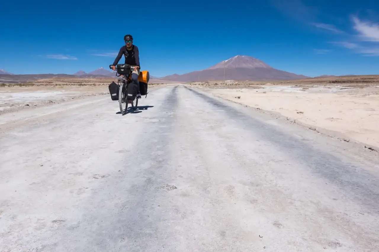 Rowerzysta przemierza pustynną drogę w Boliwii, kraju słynącym z surowych krajobrazów i wulkanów.