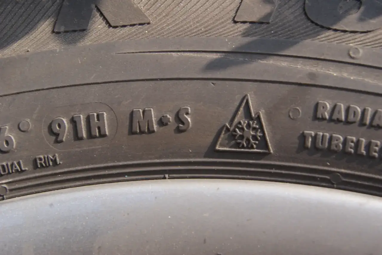 Opona z oznaczeniem M+S i symbolem płatka śniegu w górze. Tak odróżnić opony zimowe od letnich.