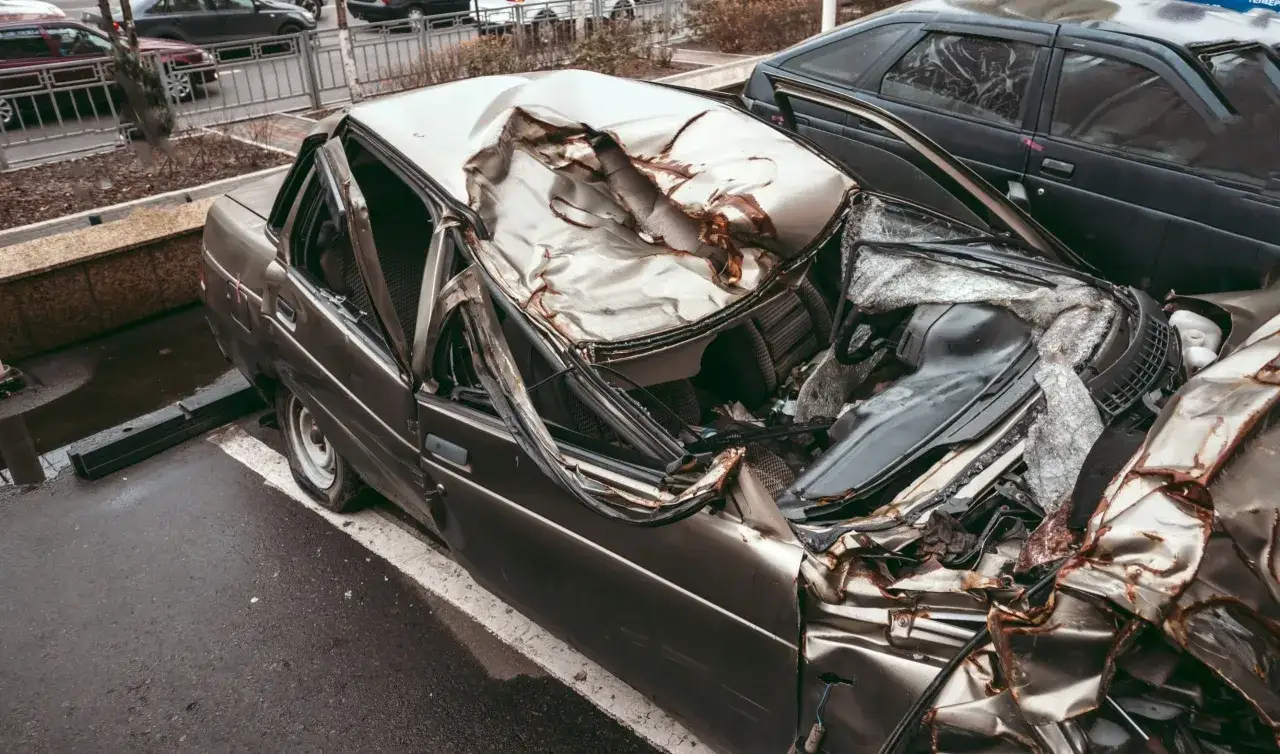 Zgnieciony samochód, którego dach jest całkowicie zniszczony, wygląda jak po wypadku. To nie jest instrukcja, jak zezłomować auto.