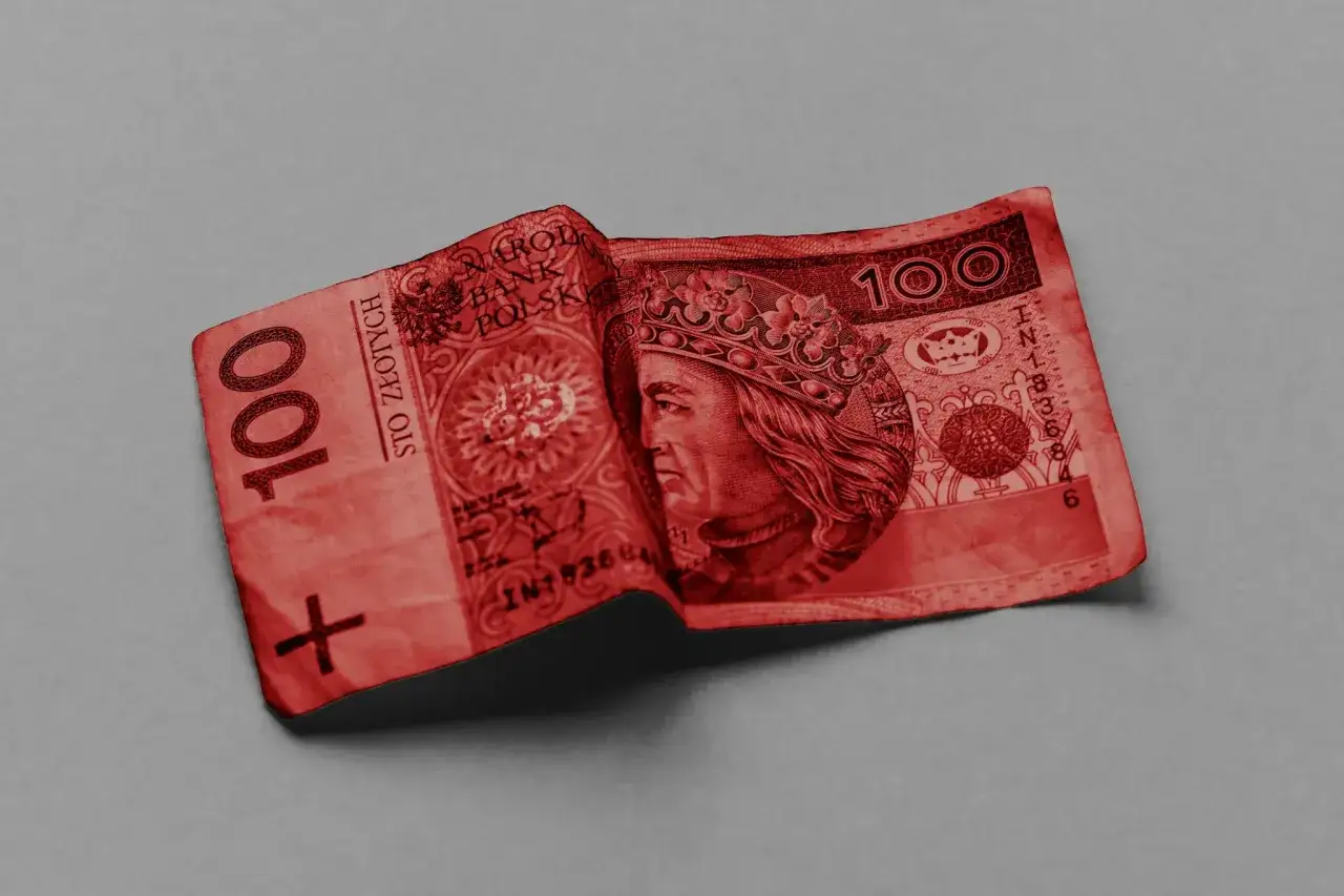 Czerwony banknot 100 zł, z wizerunkiem króla, leży pognieciony. Może to symbolizować problemy finansowe lub pozew.