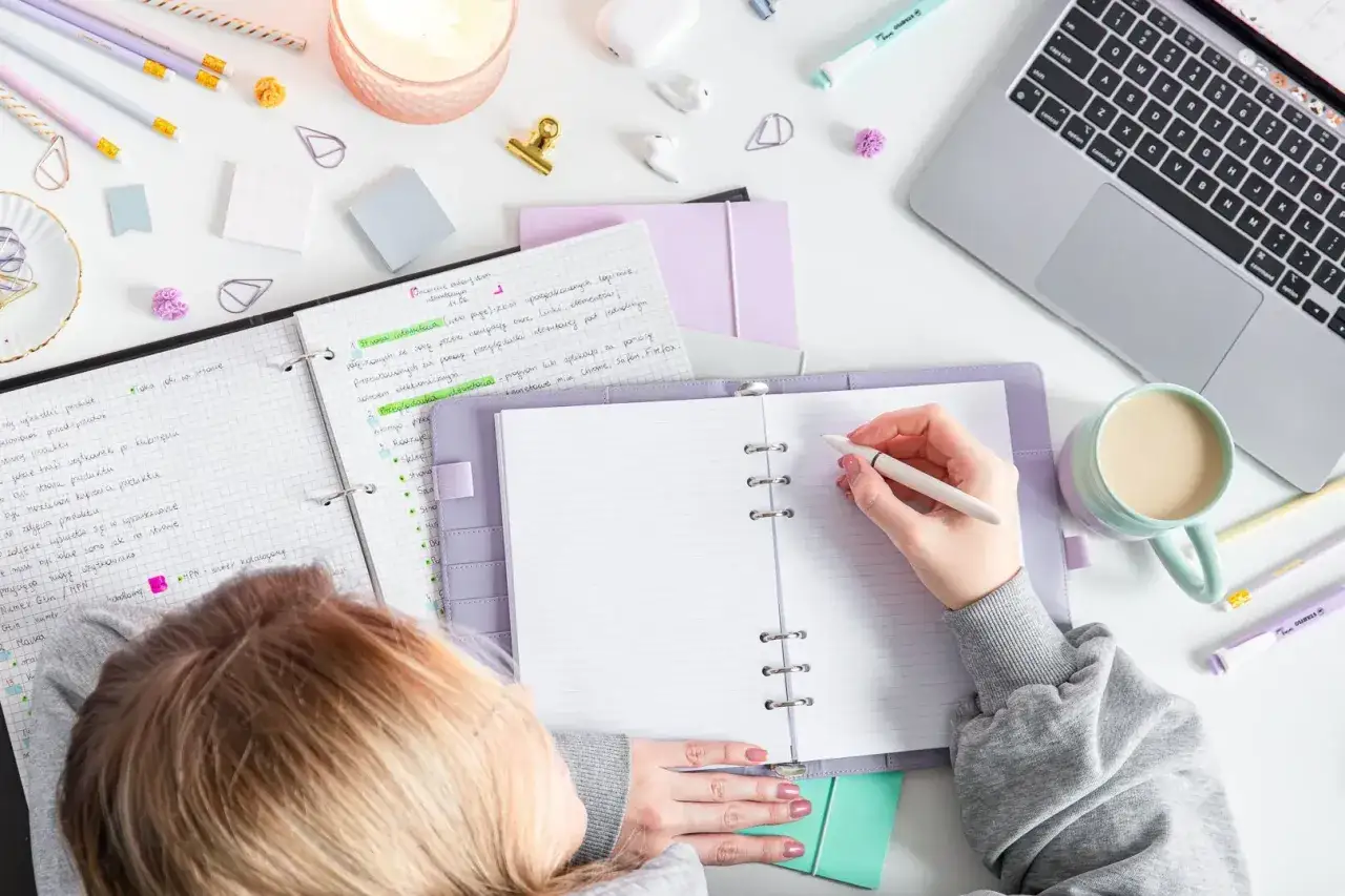 Osoba planująca rozw&oacute;j osobisty z notatnikiem i długopisem