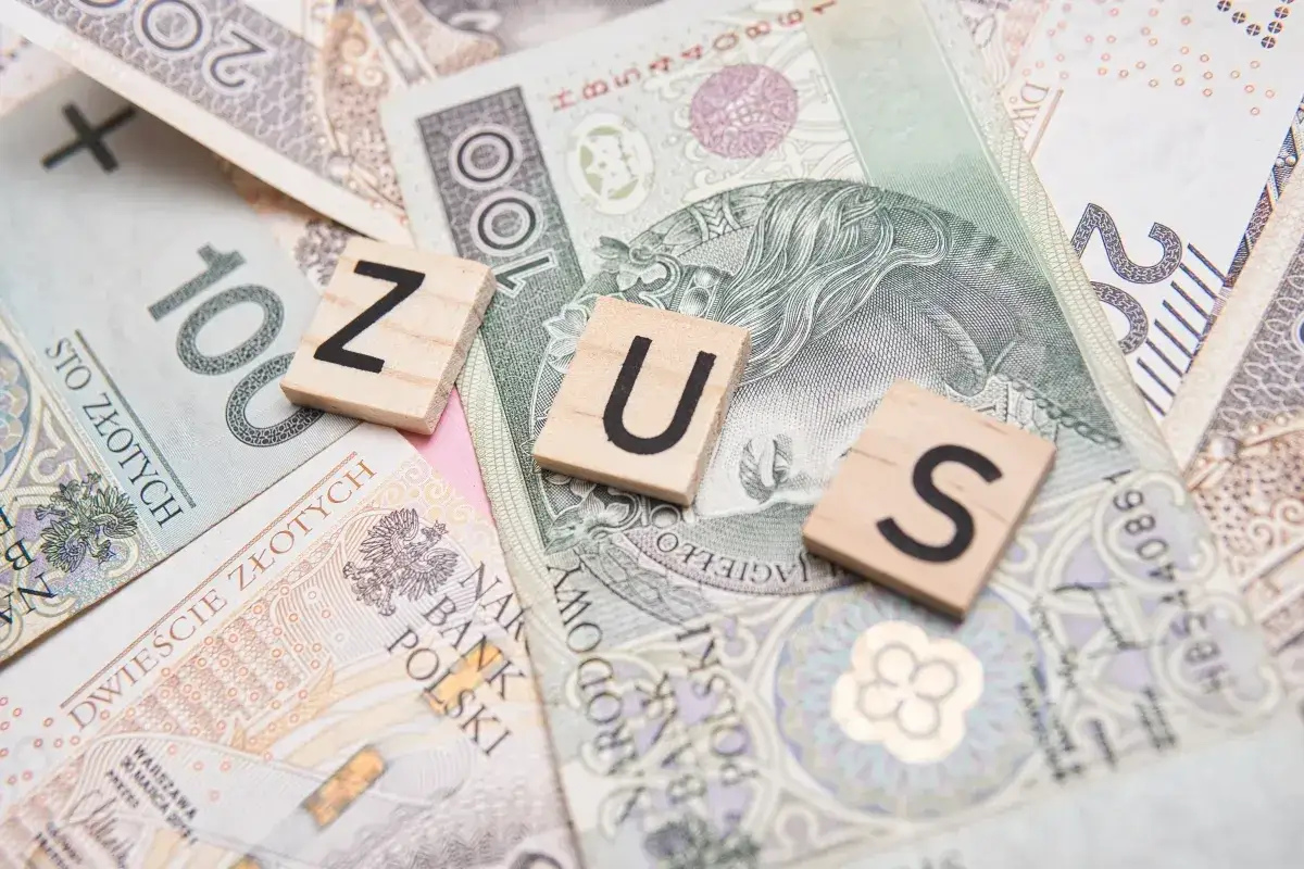 Litery ZUS na tle polskich banknotów. Czy dodatek pielęgnacyjny jest opodatkowany?