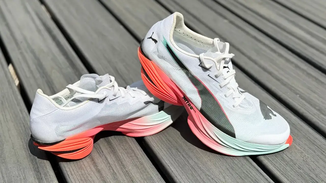 Białe buty do maratonu Puma z pomarańczowo-miętową podeszwą, gotowe na długie trasy.