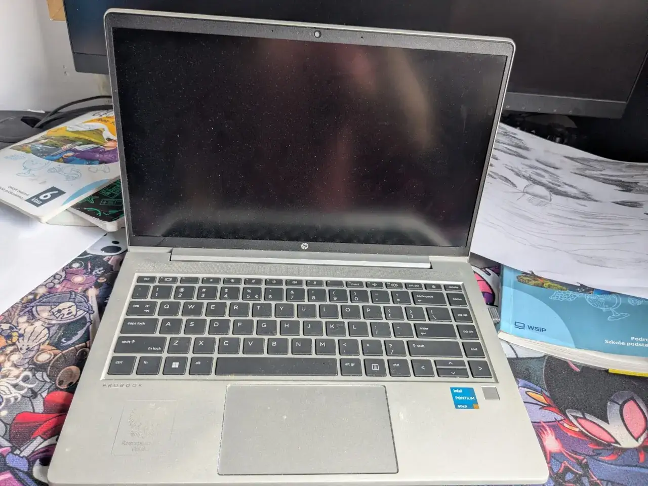 Laptop HP ProBook na biurku, obok podręczników. Czy uczniowie dostaną laptopy?