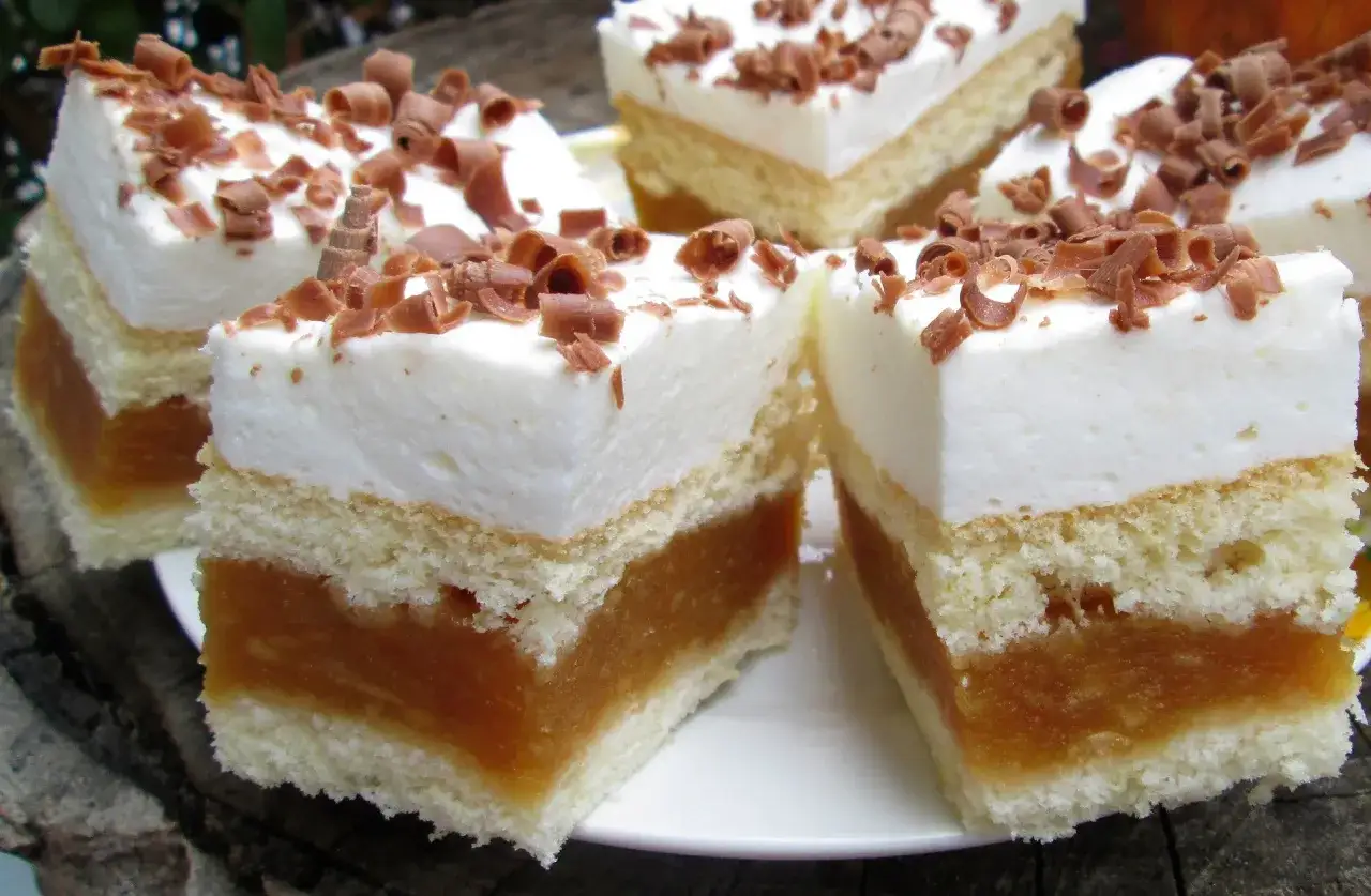 Puszysty jabłecznik na biszkopcie, przełożony pysznym jabłecznikiem i udekorowany bitą śmietaną i czekoladowymi wiórkami.