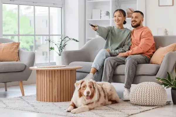 rodzina z psem oglądająca razem film na kanapie w salonie