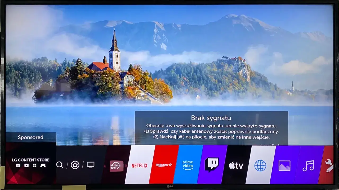 Ekran LG z widokiem na jezioro i góry. Na dole pasek z aplikacjami, w tym LG Content Store, Netflix, Prime Video. Jak zainstalować aplikacje na TV LG?