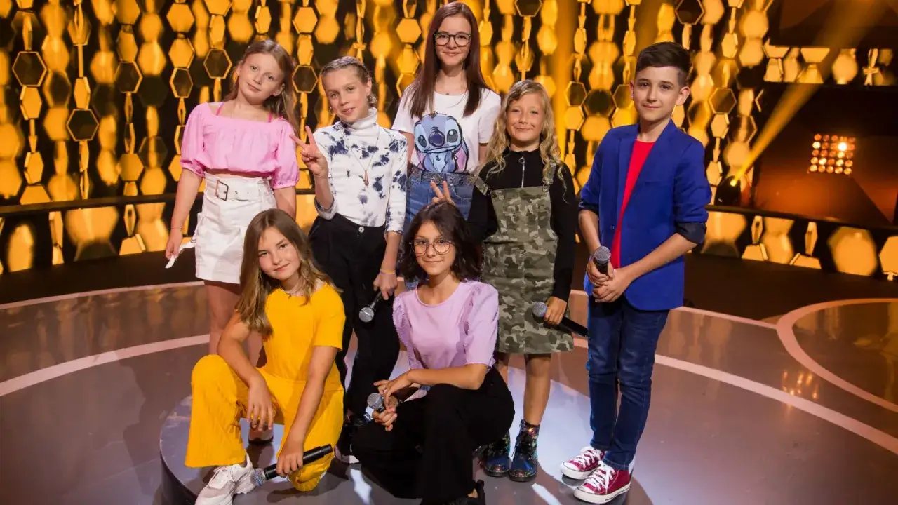 Dzieci gotowe na Eurowizję Junior Polska. Młodzi artyści z mikrofonami na scenie, pełni nadziei na zwycięstwo.