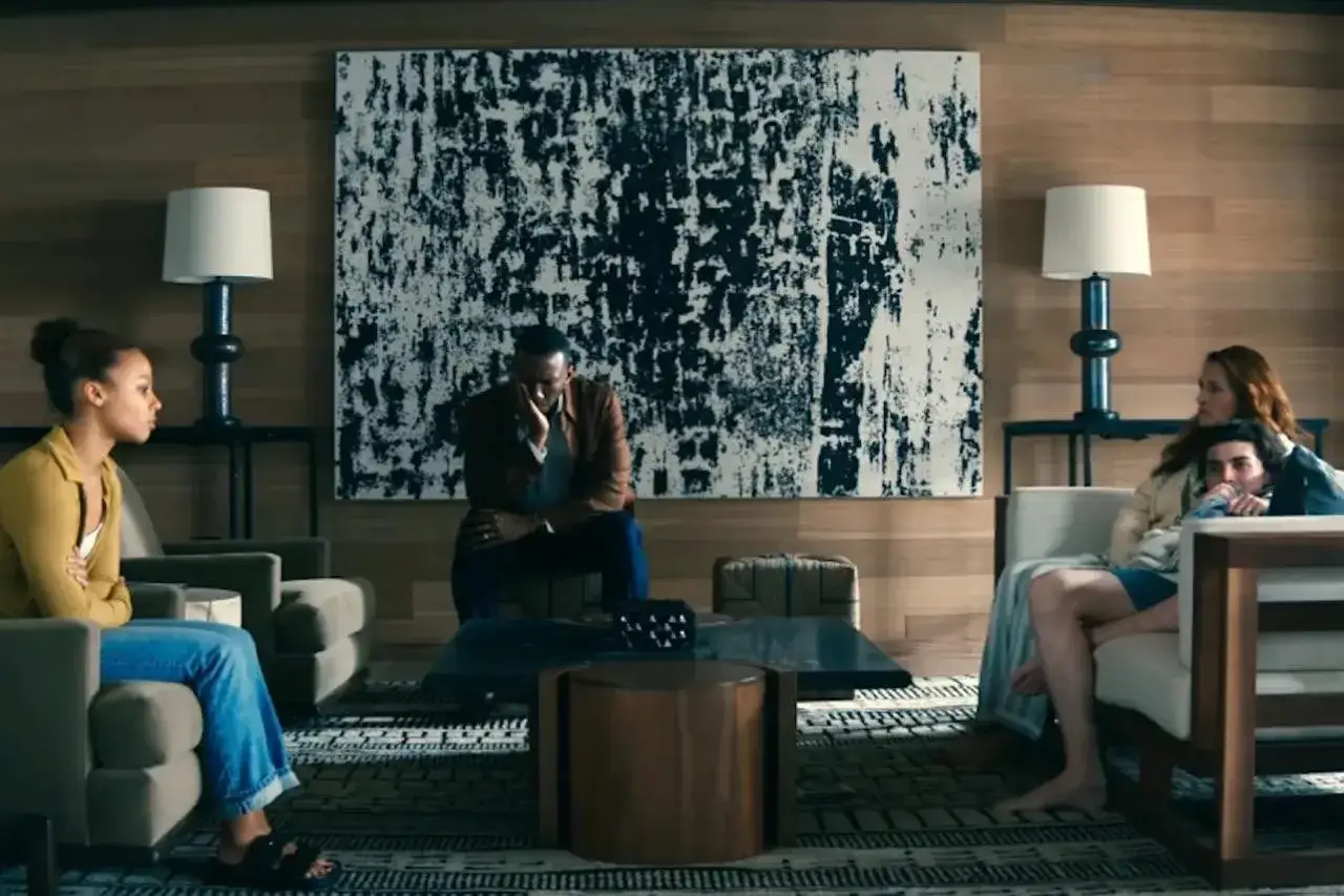 Cztery osoby siedzą w nowoczesnym salonie, pr&oacute;bując zostawić świat za sobą.