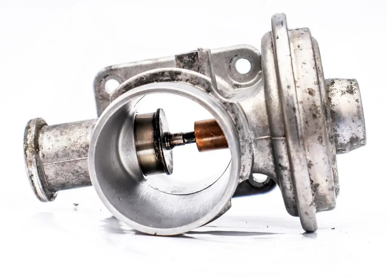 Metalowy zawór EGR z widocznymi śladami zużycia, mogącymi wskazywać na uszkodzony EGR objawy.