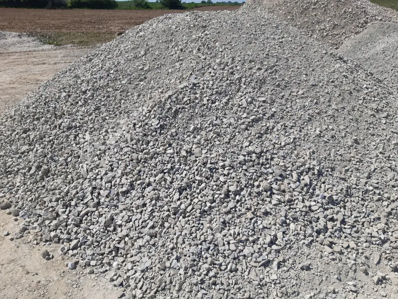 Duża hałda tłucznia, idealnego na podbudowę pod kostkę brukową. Zastanawiasz się, ile kosztuje kamień pod kostkę? Ten materiał budowlany jest kluczowy dla trwałości nawierzchni.