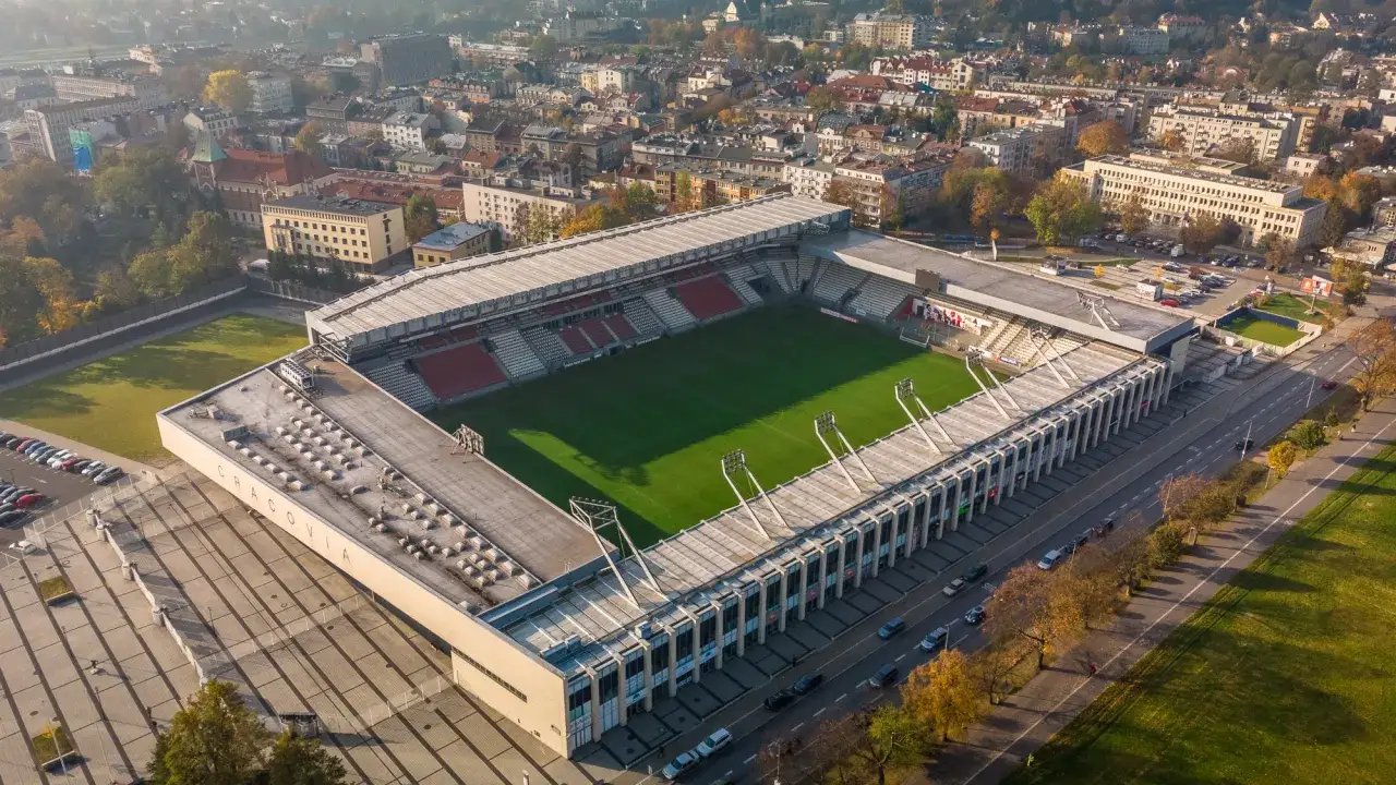 Stadion Cracovii z lotu ptaka. Widoczna zielona murawa, trybuny i otaczające budynki. Pojemność stadionu Cracovii robi wrażenie.
