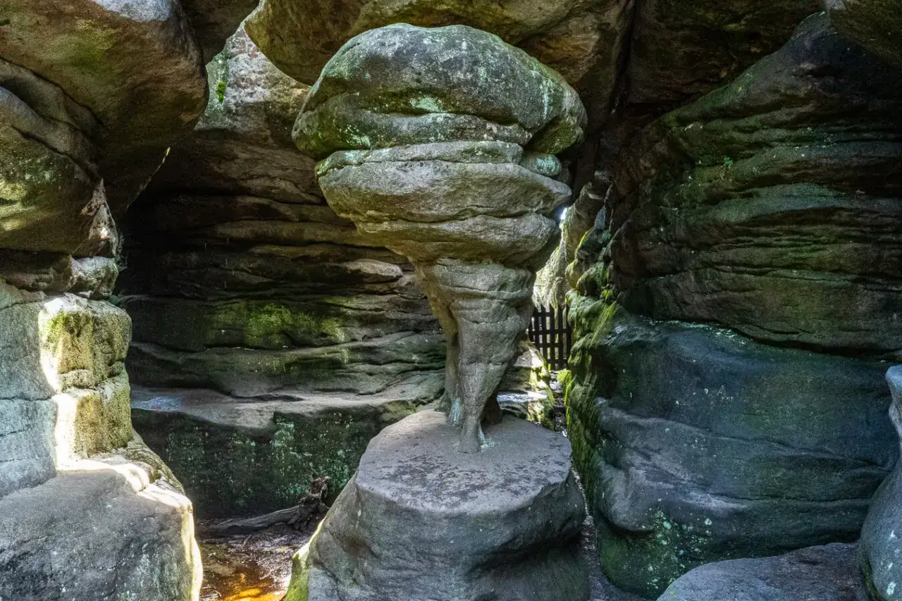 Niezwykłe błędne skały tworzą naturalny tunel. W centrum stoi kamienna forma przypominająca grzyb lub klepsydrę.