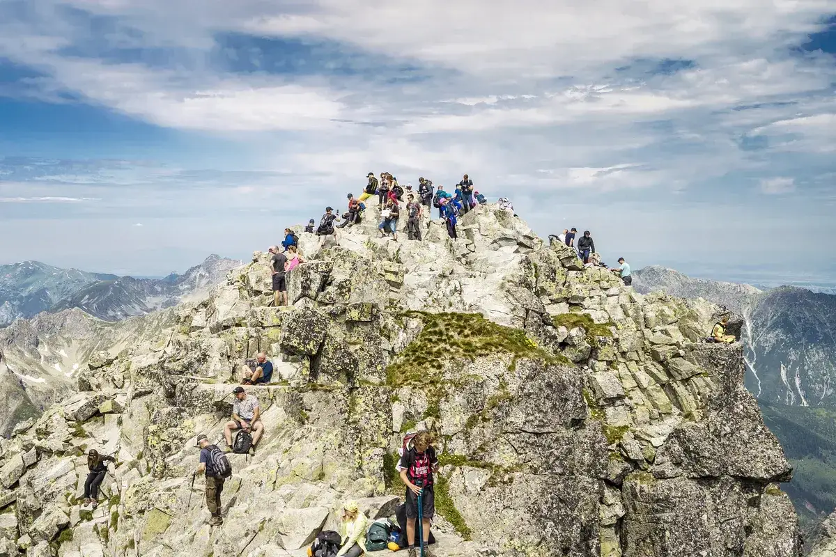 Tłum turyst&oacute;w na szczycie Rys&oacute;w. Ile czasu zajmuje wejście? Widok na Tatry.
