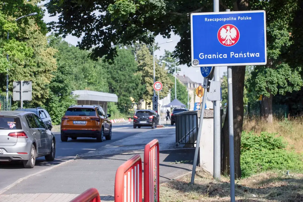 Znak graniczny Rzeczypospolitej Polskiej. Samochody zbliżają się do granicy, zastanawiając się, ile wódki można przewieźć do Niemiec.