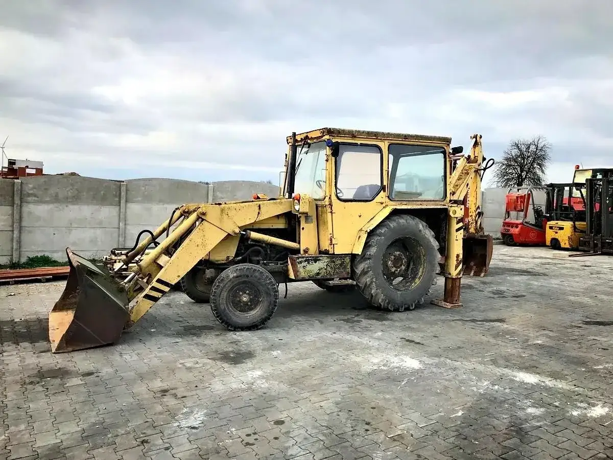 Żółta koparko-ładowarka Ostrówek. Zastanawiasz się, czy warto kupić koparkę Ostrówek? Ta maszyna czeka na nowe życie.