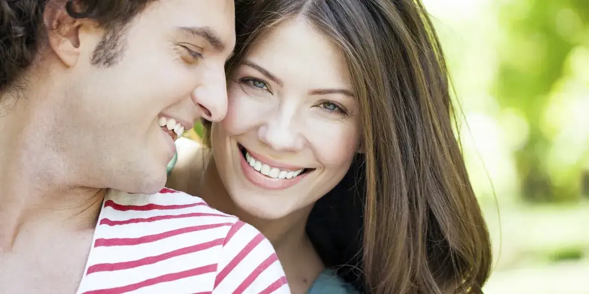 Kobieta aktywnie słuchająca mężczyzny, z uwagą i uśmiechem