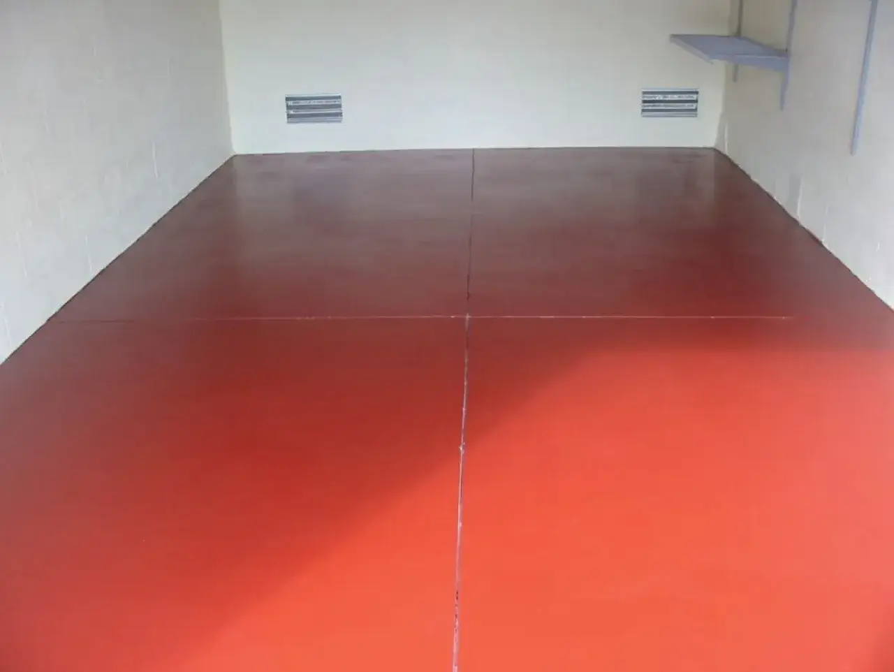 Czerwona farba do betonu w garażu nadaje mu nowoczesny wygląd.