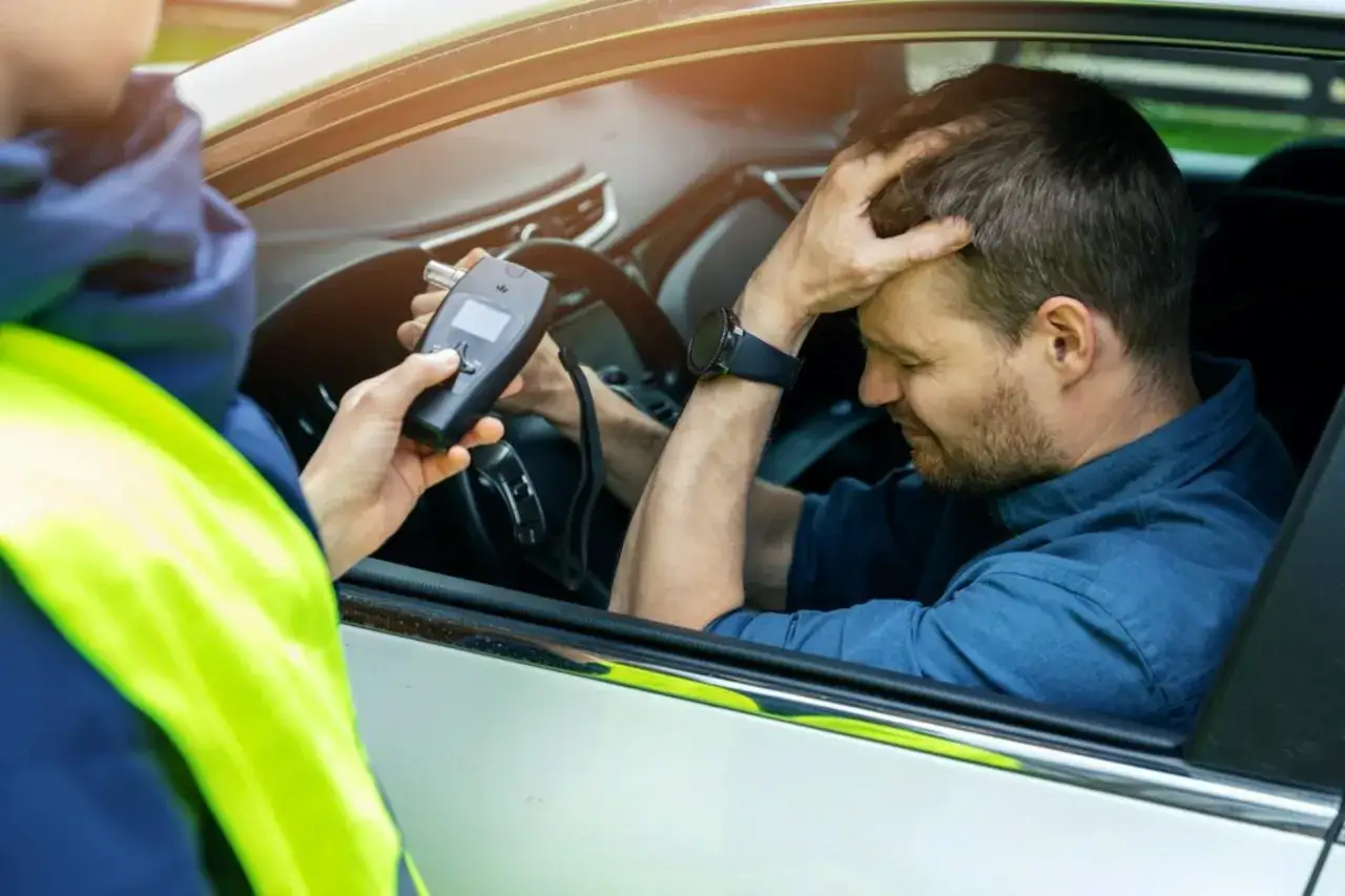 Policjant z alkomatem w ręku, kierowca z ręką na głowie. Od kiedy jazda pod wpływem alkoholu jest przestępstwem, takie widoki stają się coraz częstsze.