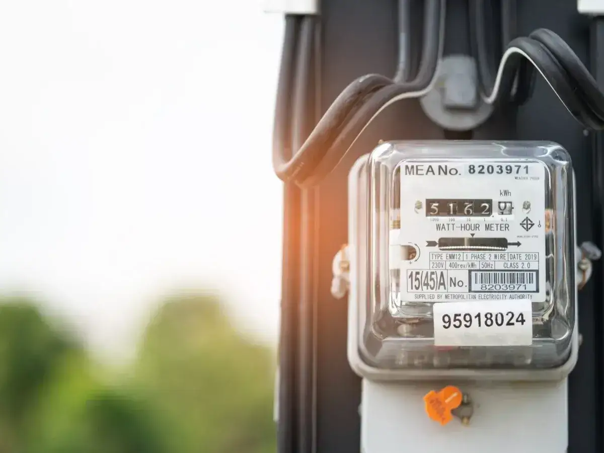 Szklana obudowa licznika energii elektrycznej z widocznymi cyframi i kodami. Zapisuje zużycie prądu, a jego numery identyfikacyjne to kody licznika energii elektrycznej.