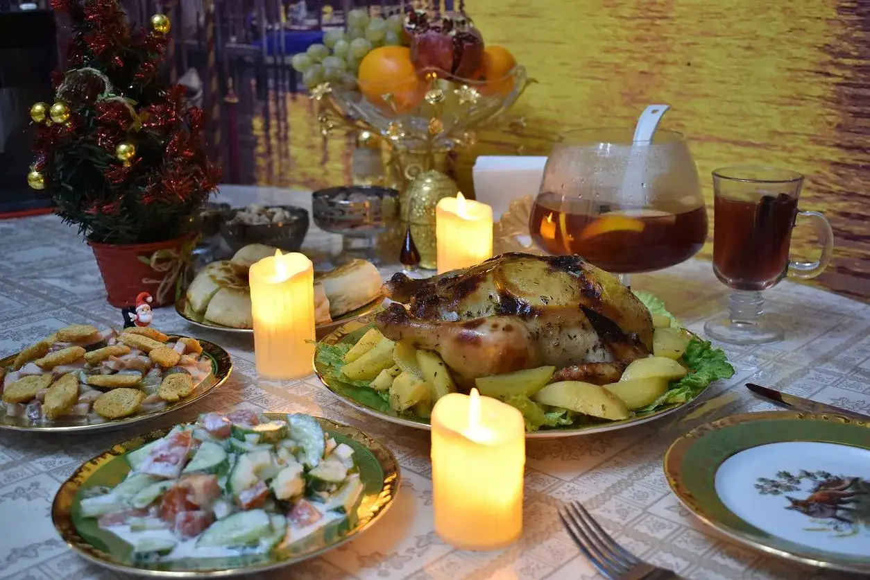 Co zrobić na świąteczny obiad? Pieczony kurczak z ziemniakami, sałatki, owoce i gorący napój przy blasku świec.