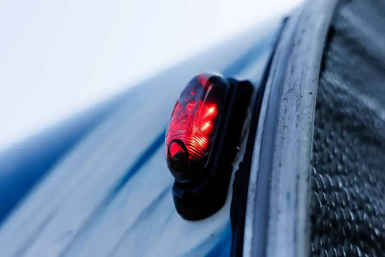 Czerwone światło cofania świeci na tle niebieskiego pojazdu.