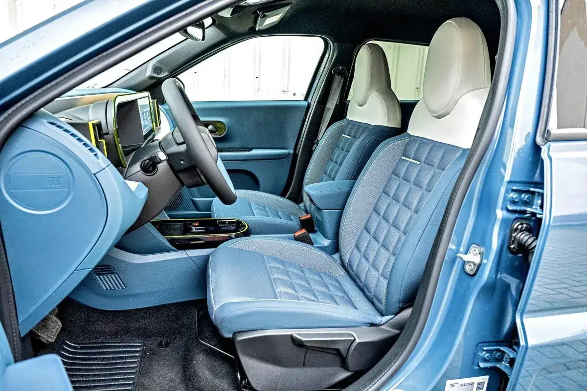 Wnętrze nowego Fiata Panda automat. Błękitne, pikowane fotele i nowoczesny design deski rozdzielczej.