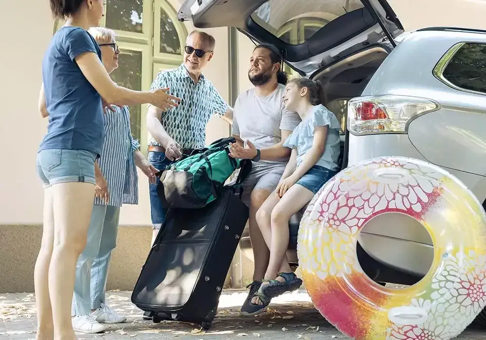 rodzina pakująca samoch&oacute;d na wakacje
